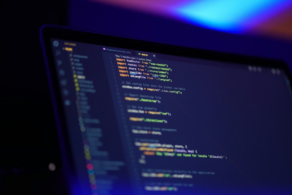 Colorful code on a laptop screen with blue ambient light, representing mobile app development